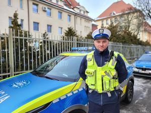 mł. asp. Łukasz Kozłowski przy radiowozie