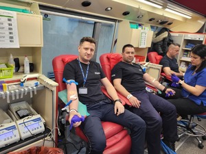 Dwóch policjantów w granatowych koszulkach oddaje krew.