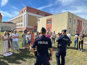 policjanci z ewakuowanymi pracownikami