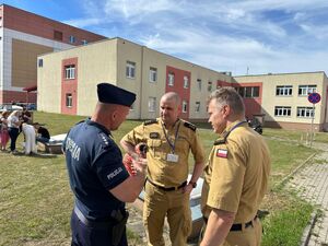 policjanci ze strażakami w trakcie odprawy